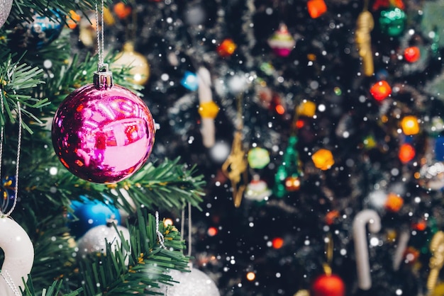 Árbol de Navidad decorado con adornos de colores sobre fondo borroso de luz bokeh brillante