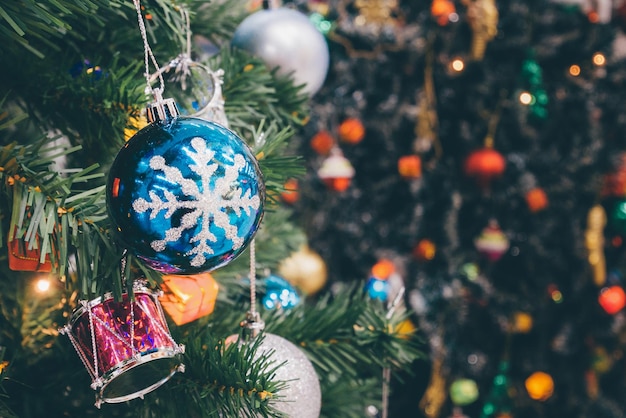 Árbol de Navidad decorado con adornos de colores sobre fondo borroso de luz bokeh brillante