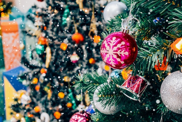 Árbol de Navidad decorado con adornos de colores sobre fondo borroso de luz bokeh brillante