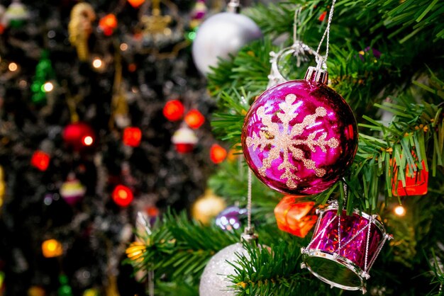 Árbol de Navidad decorado con adornos de colores sobre fondo borroso de luz bokeh brillante