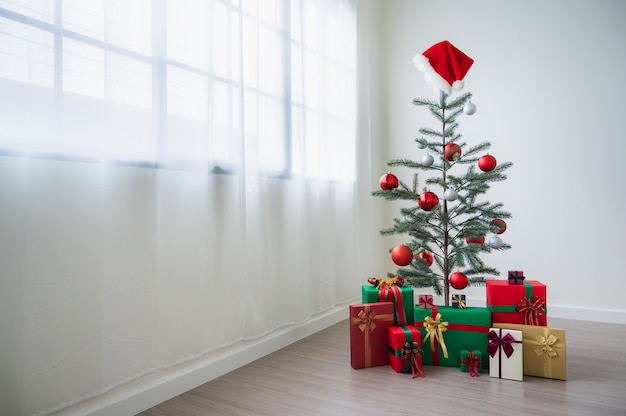 Árbol de Navidad decorado con adornos y regalos.