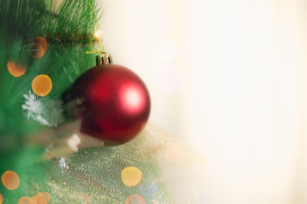 Árbol de Navidad decorado con arcos de bolas y luces sobre un fondo blanco.