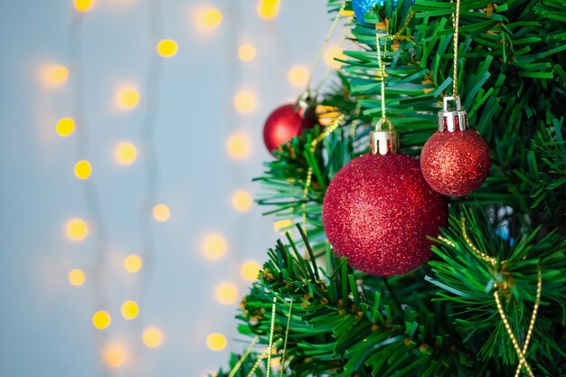 Árbol de Navidad decorado con bola roja sobre fondo de ramas de pino