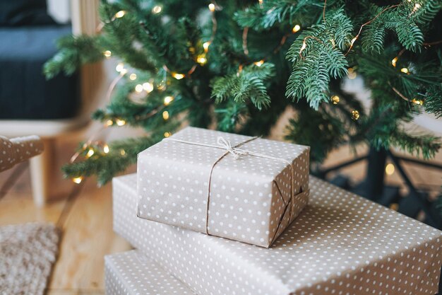 Árbol de Navidad decorado con cajas de regalo artesanales ecológicas en el dormitorio en un interior luminoso en el hogar