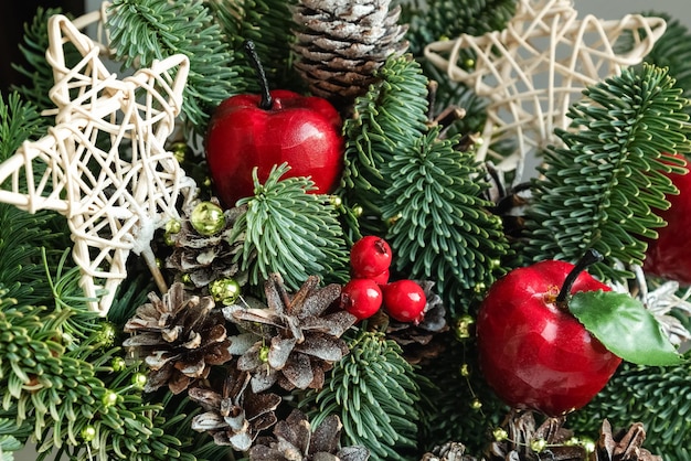 Árbol de Navidad decorado con conos secos, manzanas decorativas y estrellas de mimbre.