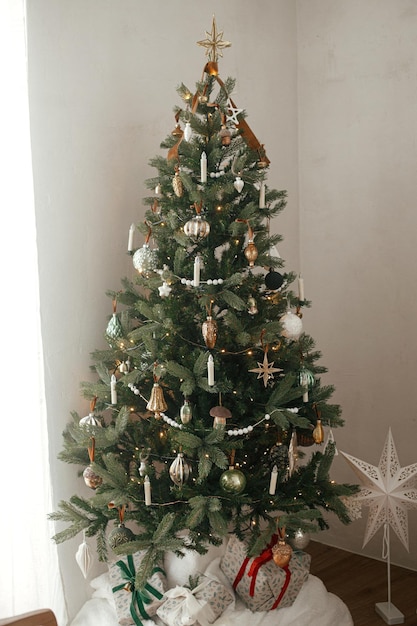 Árbol de Navidad decorado con estilo en una habitación escandinava con regalos de Navidad envueltos Feliz Navidad y Felices Fiestas Árbol de navidad vintage moderno