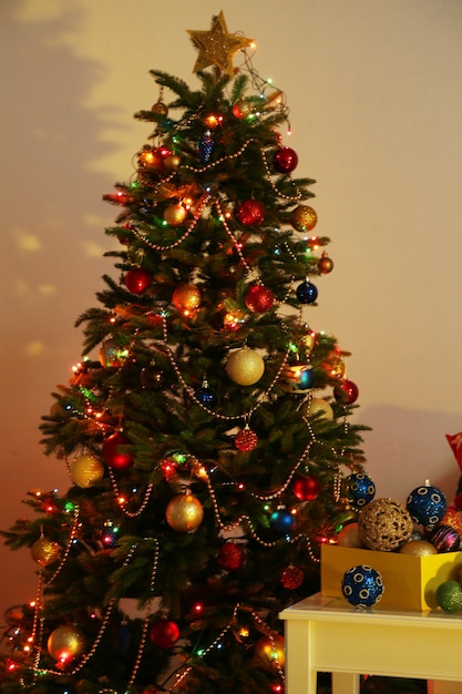 Árbol de Navidad decorado en el fondo interior de una casa en la noche