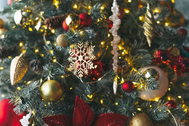 Árbol de Navidad decorado con juguetes dorados y rojos con el fondo texturizado de bokeh de luces