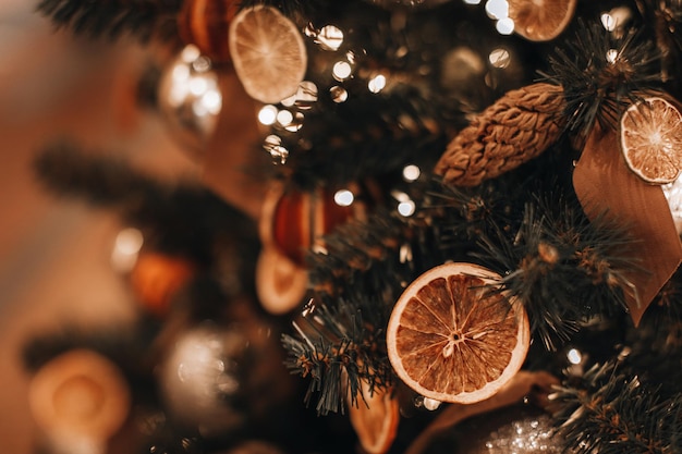 Árbol de Navidad decorado con naranjas secas y conos de pino Detalles mágicos y acogedores y luces doradas bokeh