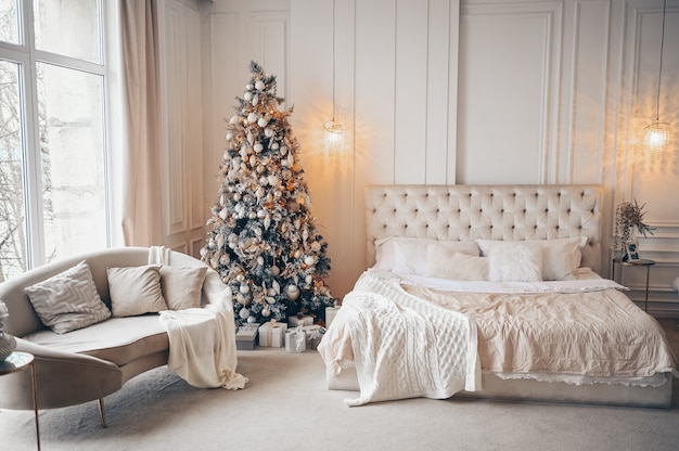 Árbol de Navidad decorado con regalos en el interior del dormitorio clásico blanco