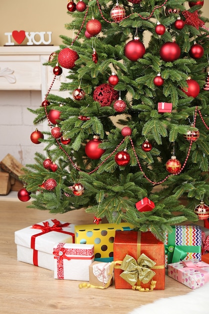 Árbol de Navidad decorado con regalos en primer plano de la habitación