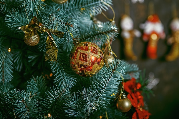 Árbol de Navidad decorado sobre fondo borroso, brillante y de hadas. Adornos navideños de hermosos colores colgando de un árbol de navidad con reflejos brillantes