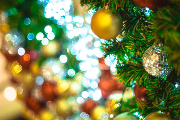 Árbol de Navidad de enfoque selectivo con bolas de discoteca de plata navideñas y bola de oro y luces con espacio de copia en fondo bokeh borroso