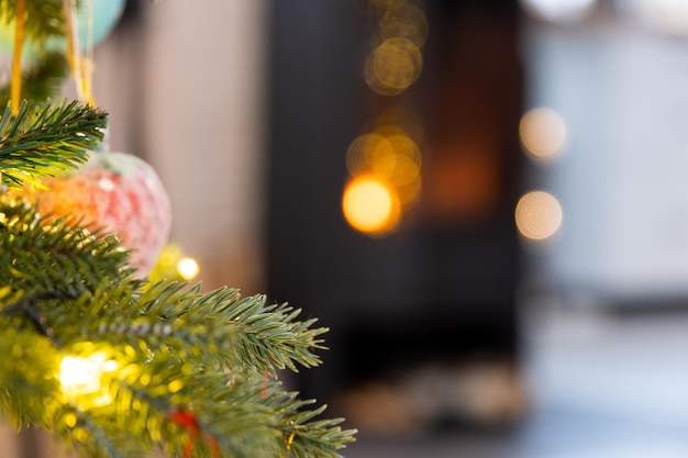 Árbol de Navidad en el fondo de una chimenea encendida primer plano Navidad Año Nuevo atmósfera festiva de cuento de hadas luces bokeh Copyspace tarjeta de felicitación