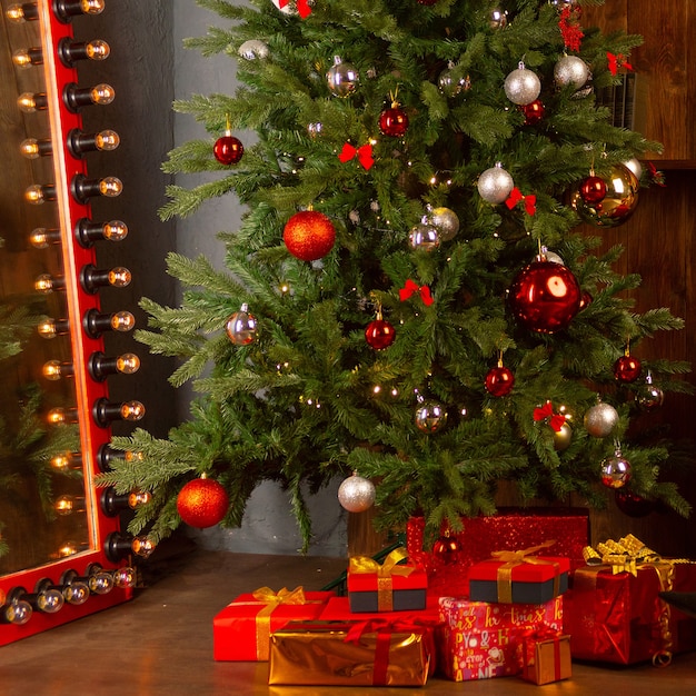 Árbol de Navidad con una guirnalda en el fondo de una pared de madera