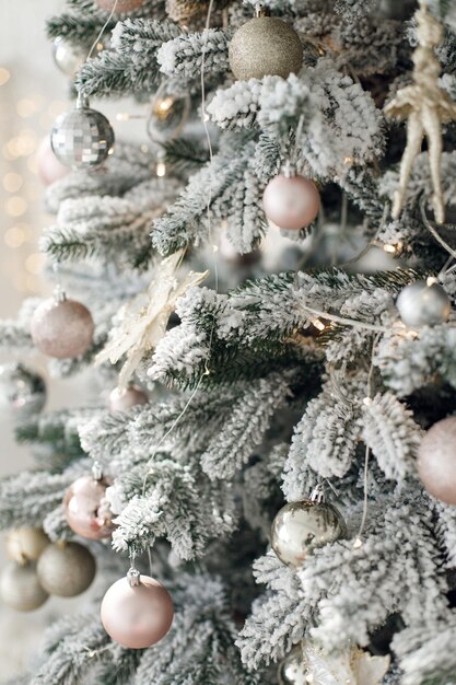 Árbol de navidad con guirnaldas de luces y juguetes blancos