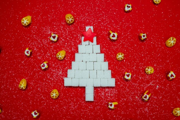 Árbol de Navidad hecho de azúcar y dulces Fotografía conceptual Dieta Banner Año nuevo Fondo rojo