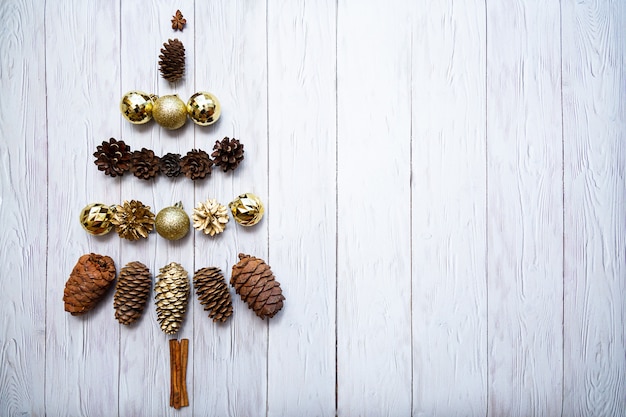 Árbol de Navidad hecho de bolas de Navidad doradas conos de cedro y piñas