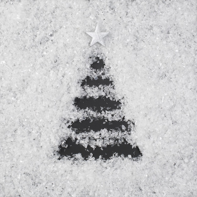 Árbol de Navidad hecho en nieve sobre un fondo negro. Vista superior. Endecha plana