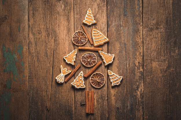 Árbol de Navidad hecho de pan de jengibre, canela y limón sobre un fondo de madera. El concepto de Navidad y año nuevo. Vista superior, horizontal.