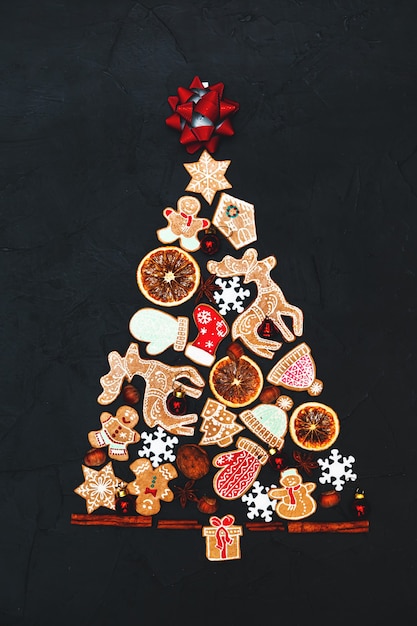 Árbol de Navidad hecho de pan de jengibre y especias sobre un fondo oscuro. Copie el espacio. Tarjeta de felicitación de Navidad y año nuevo.