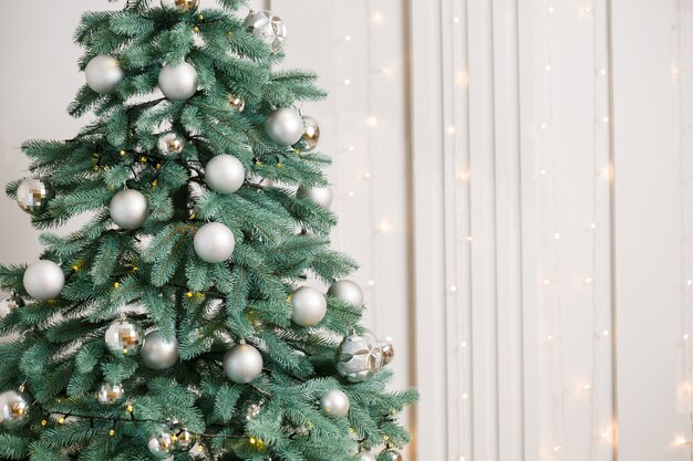 Árbol de Navidad con juguetes de adornos de plata. El año nuevo es pronto