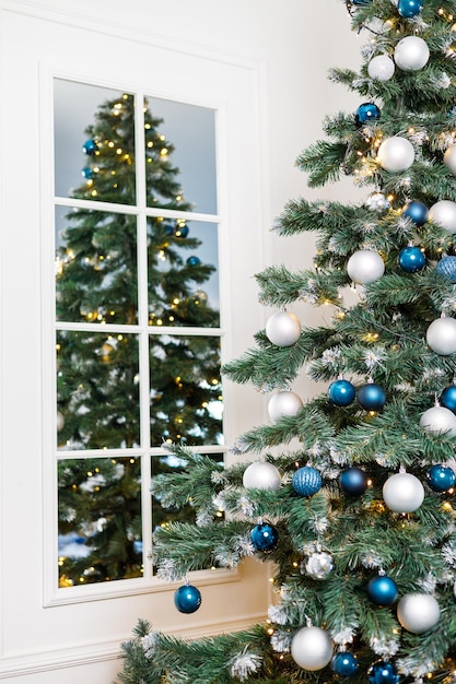 Árbol de Navidad con juguetes azules y plateados Árbol de Navidad decorado festivamente con guirnaldas Símbolo del año nuevo