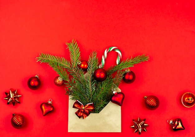 Árbol de Navidad juguetes Caramel Cane Santa en un sobre de papel sobre un fondo rojo. Concepto de Navidad