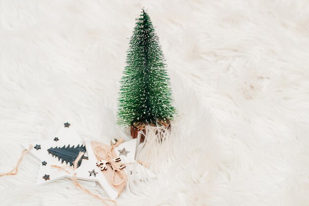 Árbol de Navidad, juguetes de madera sobre un fondo blanco esponjoso.