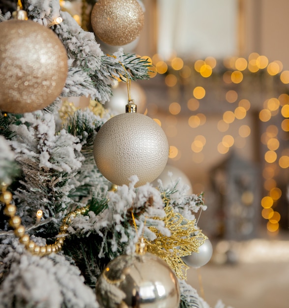 Árbol de Navidad con juguetes y nieve decorativa para un feliz año nuevo en el fondo de bokee. Fondo de Navidad dorado