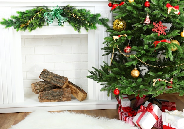 Árbol de Navidad junto a la chimenea en la habitación