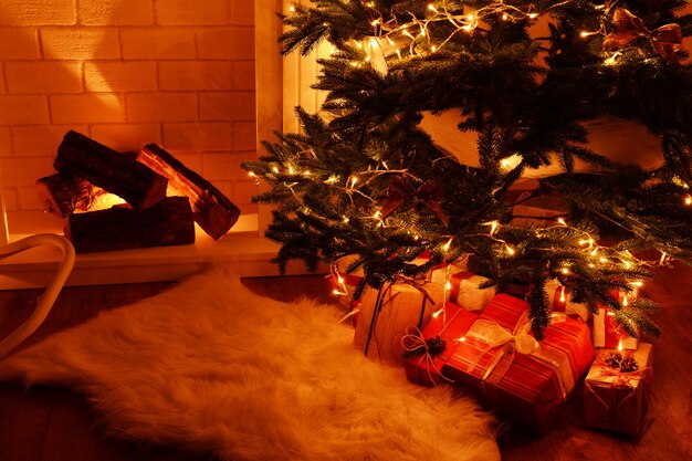 Árbol de Navidad junto a la chimenea en la habitación