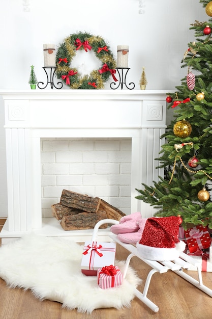 Árbol de Navidad junto a la chimenea en la habitación