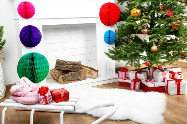 Árbol de Navidad junto a la chimenea en la habitación