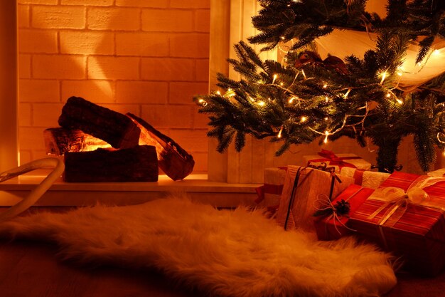 Árbol de Navidad junto a la chimenea en la habitación