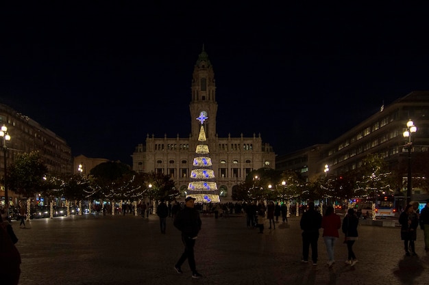 Árbol de Navidad con luces brillando en una plaza de la ciudad de Oporto Portugal