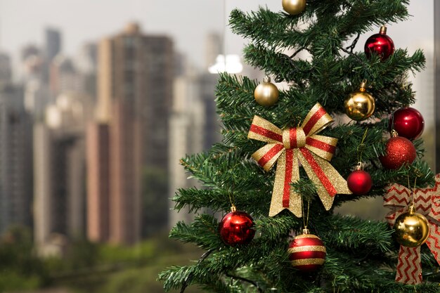 Árbol de Navidad a la luz del día, con un paisaje urbano.