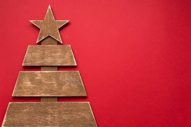 Árbol de Navidad de madera en rojo, copyspace. tarjeta de felicitación de invierno de año nuevo