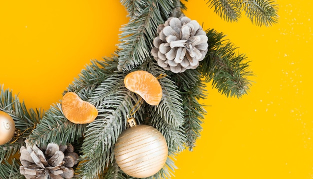 Árbol de navidad y mandarina sobre fondo amarillo