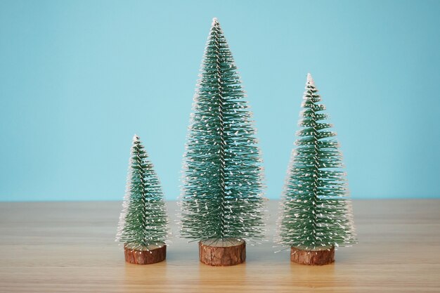 Árbol de Navidad en la mesa de madera con fondo de pared azul