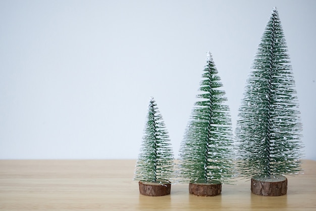 Árbol de Navidad en la mesa de madera con fondo de pared blanca