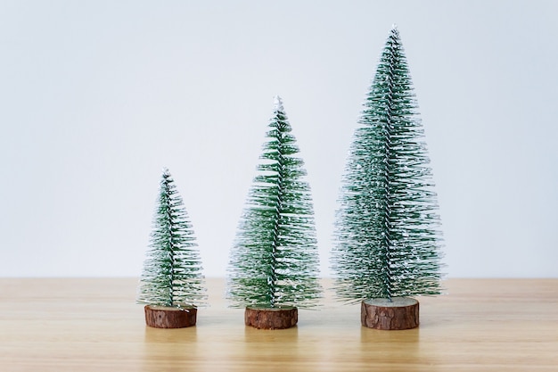 Árbol de Navidad en la mesa de madera con fondo de pared blanca