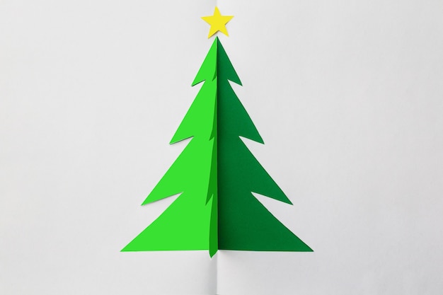 Árbol de Navidad de origami con estrella en la parte superior sobre fondo blanco.