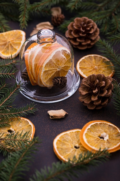 Árbol de Navidad, piñas y naranjas en mesa