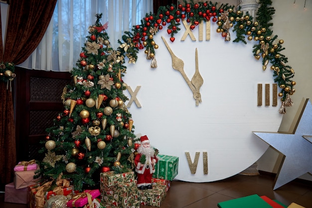 Árbol de navidad con regalos y un reloj