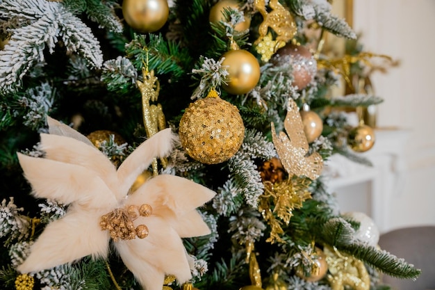 Árbol de navidad ricamente decorado con adornos doradosÁrbol de navidad con guirnaldas de adornos dorados y velasfeliz año nuevo Enfoque selectivo