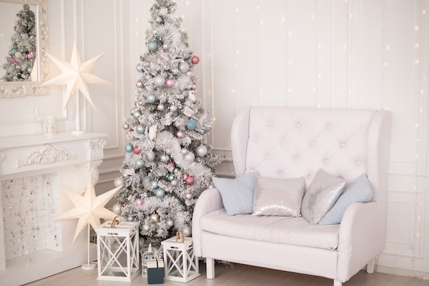 Árbol de Navidad en una sala blanca decorada