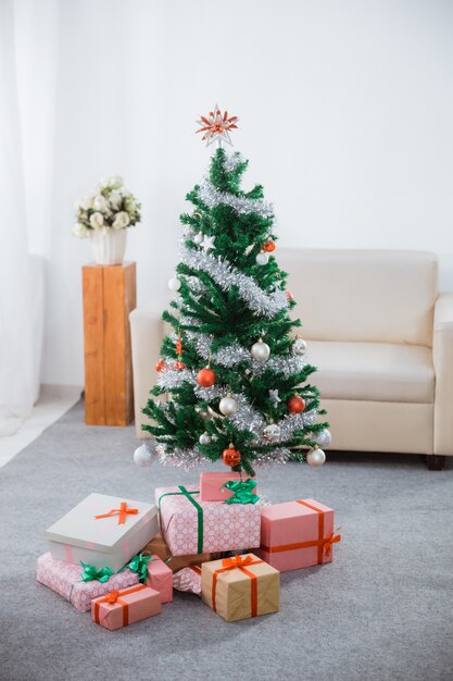 Árbol de Navidad en la sala de estar con muchas cajas de regalo.