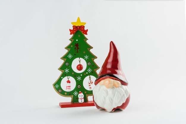 Árbol de Navidad y Santa Claus con adornos sobre fondo blanco. Decoración navideña. Enfoque selectivo.