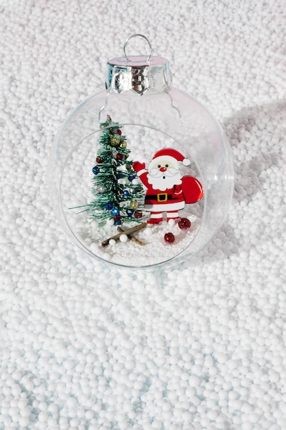 Árbol de Navidad y Santa Claus dentro de la chuchería de Navidad con tarjeta de feliz año nuevo de sombra de día soleado